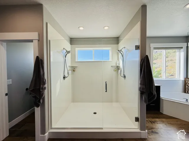 Enclosed walk-in shower with dual shower heads, integrated shelving, and a glass door