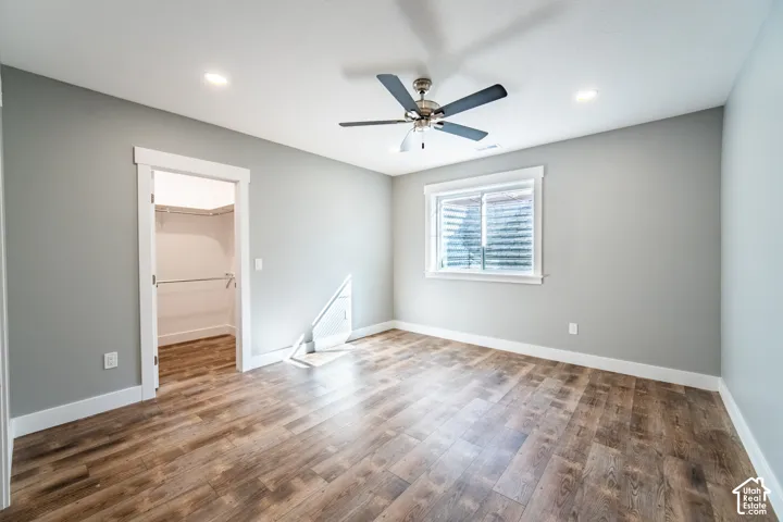 EnSuite bedroom with wood finished floors, ceiling fan, and recessed lighting
