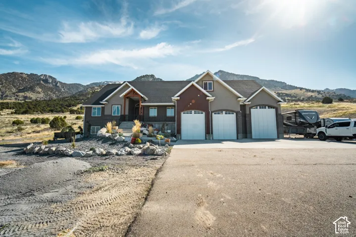 View of front of home featuring a mountain view, driveway, an attached garage, and stucco siding