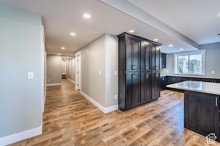 Kitchen featuring wood-style flooring, recessed lighting, and light stone countertops
