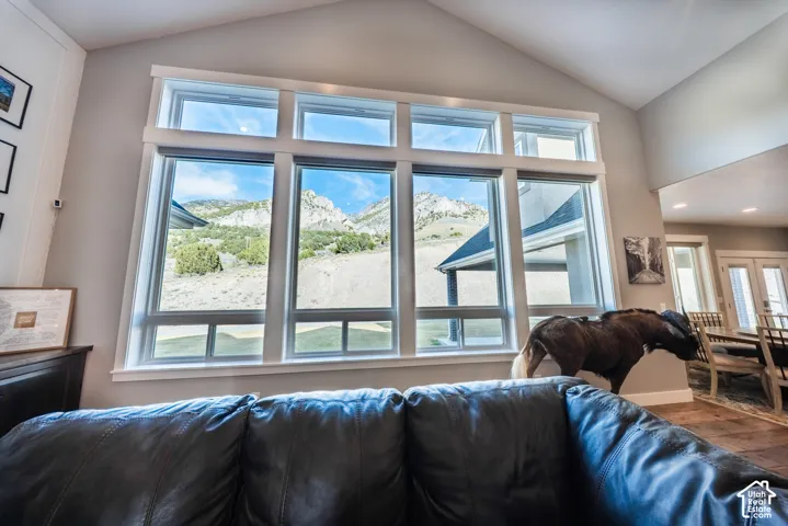 Living area featuring vaulted ceiling, plenty of natural light, mountain views, and wood finished floors