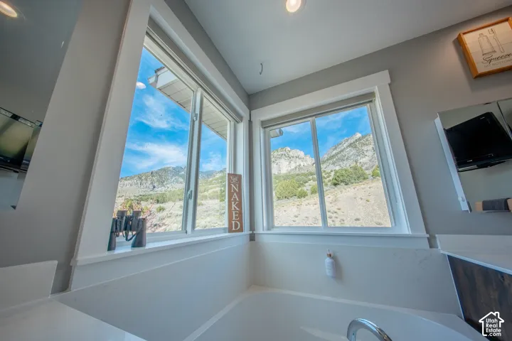 Bathroom with a mountain view and a bath