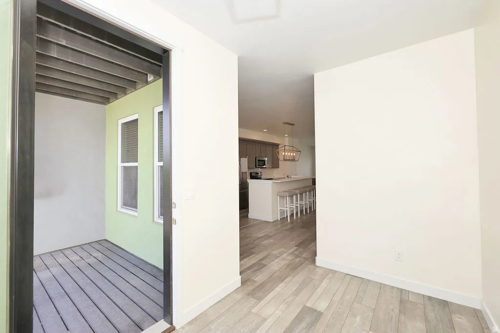Hallway with light wood-type flooring and baseboards
