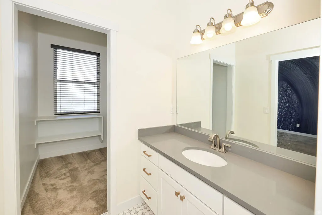 Bathroom with vanity and light colored carpet
