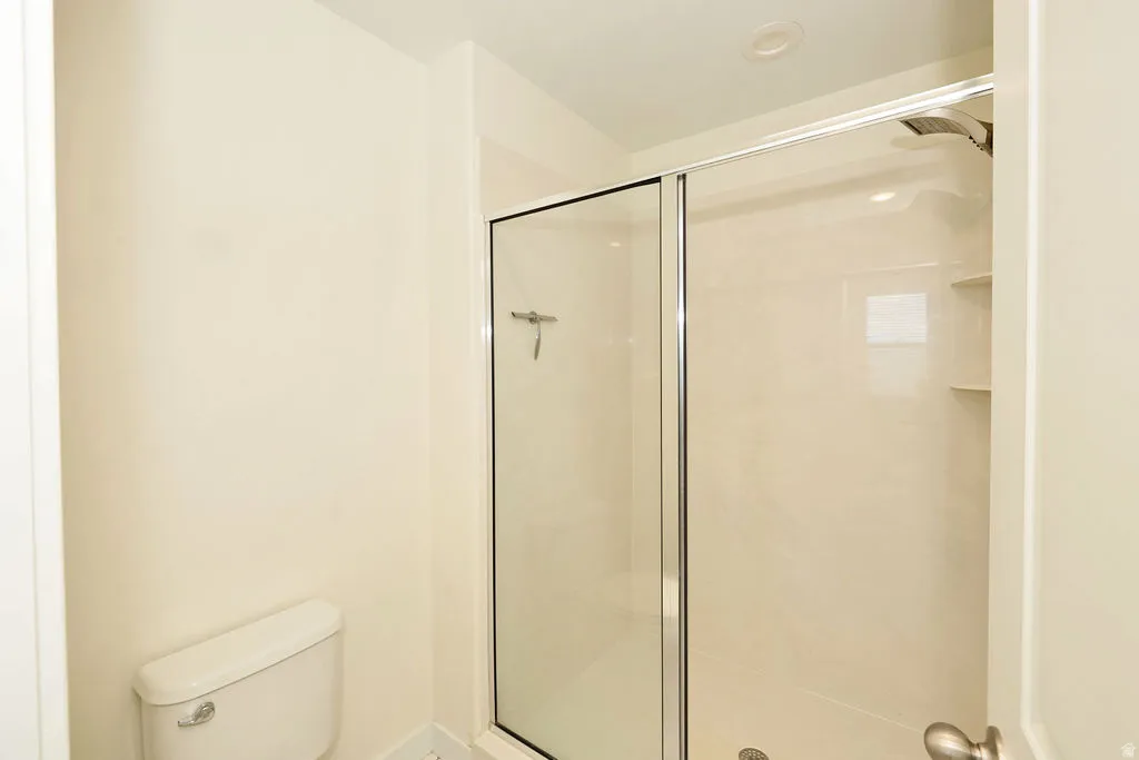Bathroom with a shower stall and toilet