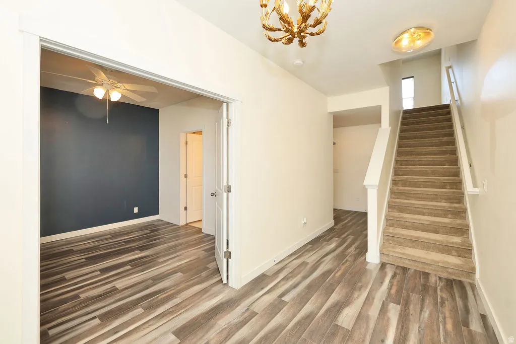 Interior space featuring dark wood-style flooring, suspended lighting, and ceiling fan