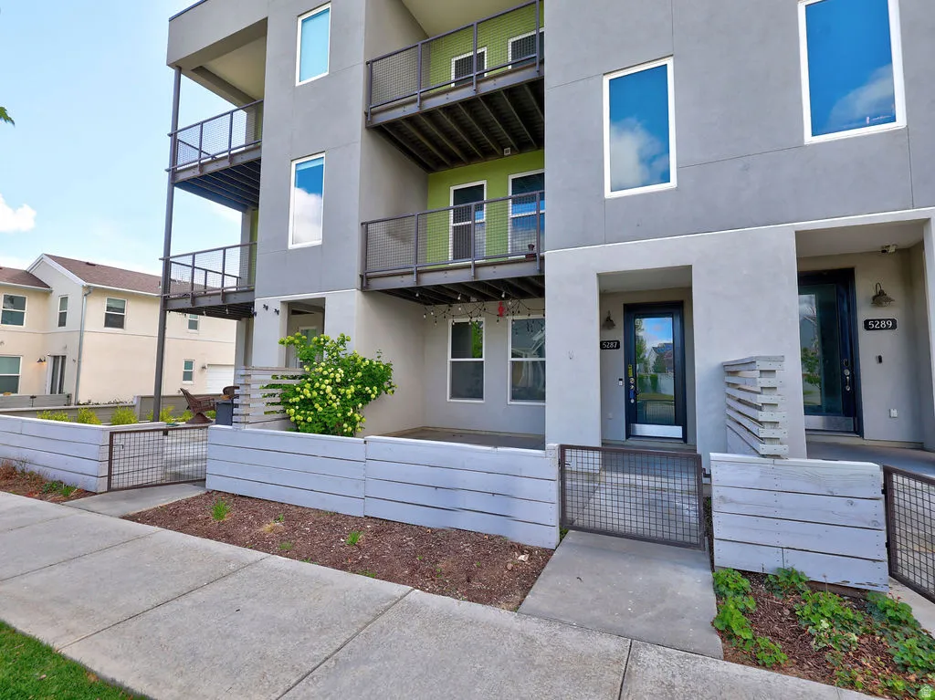 View of exterior entry featuring stucco siding and a gate