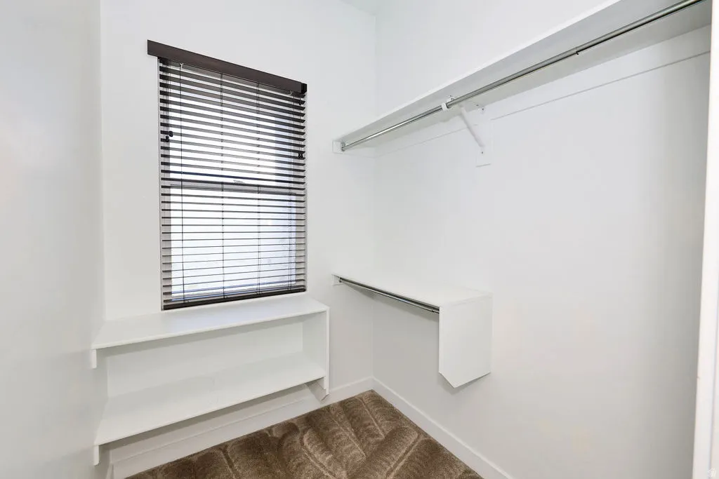 Walk in closet with dark carpet