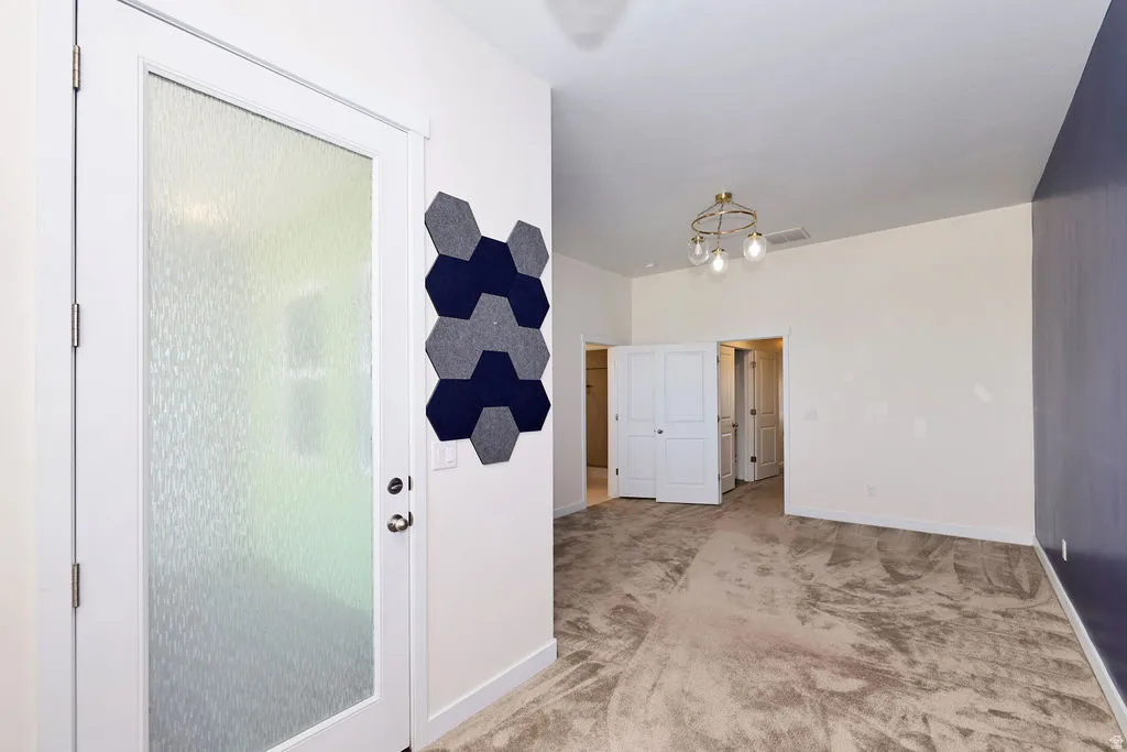 Interior space featuring baseboards and light carpet