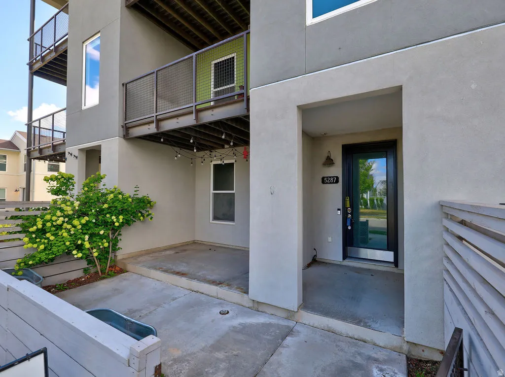 Property entrance with stucco siding and a patio