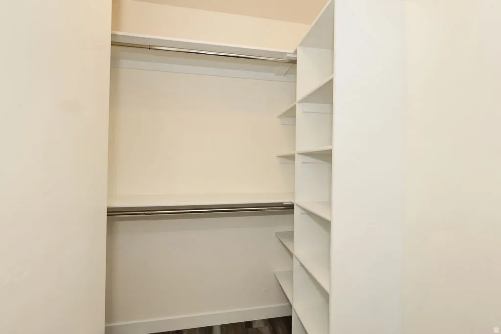Walk in closet featuring dark wood-style floors