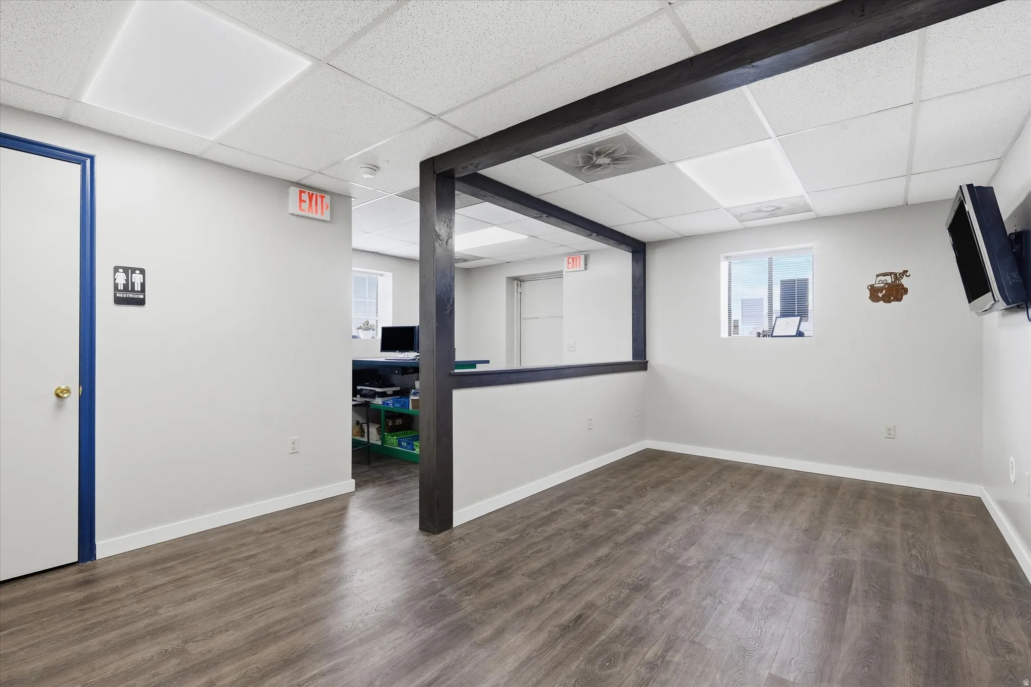 Unfurnished room featuring a drop ceiling and dark wood-style flooring