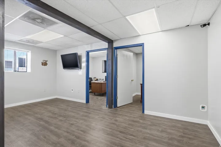 Basement featuring a drop ceiling, dark wood-type flooring, and an office area