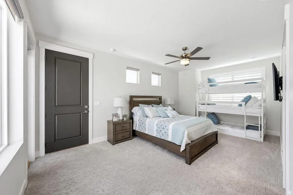 Bedroom featuring light carpet and ceiling fan