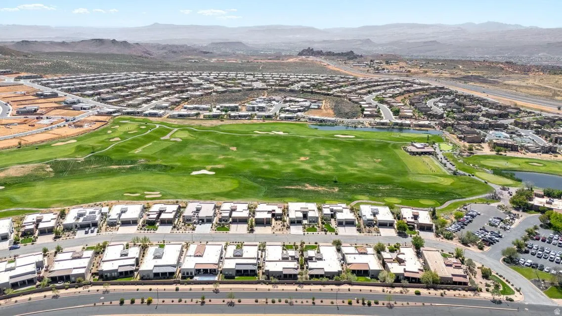 Aerial view of residential area featuring a golf course and a water and mountain view