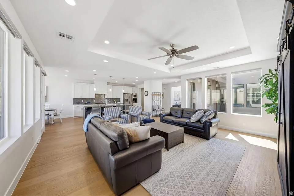 Living room featuring light wood finished floors, a ceiling fan, recessed lighting, and a barn door