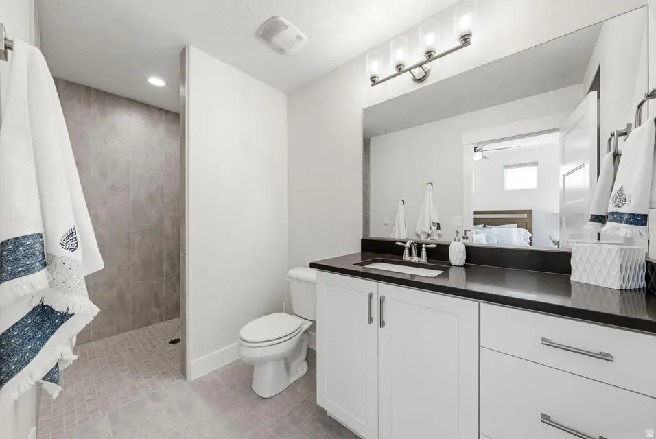 Full bathroom with vanity, walk in shower, light tile patterned flooring, ensuite bath, and recessed lighting