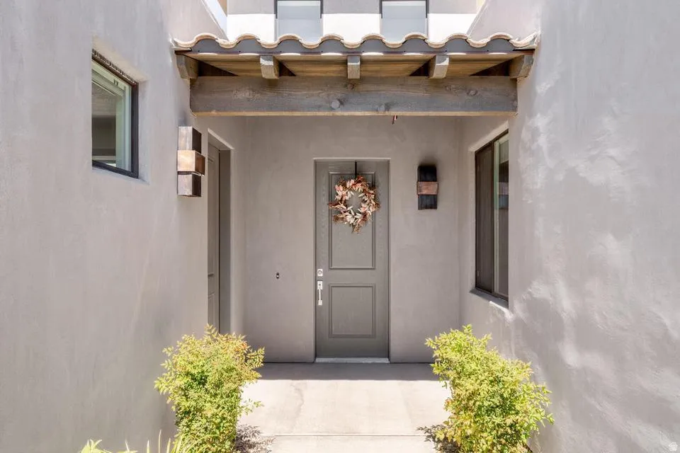 Doorway to property featuring stucco siding