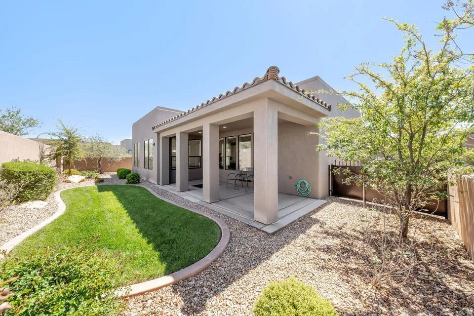 Back of property with a fenced backyard, a patio area, stucco siding, and a tiled roof