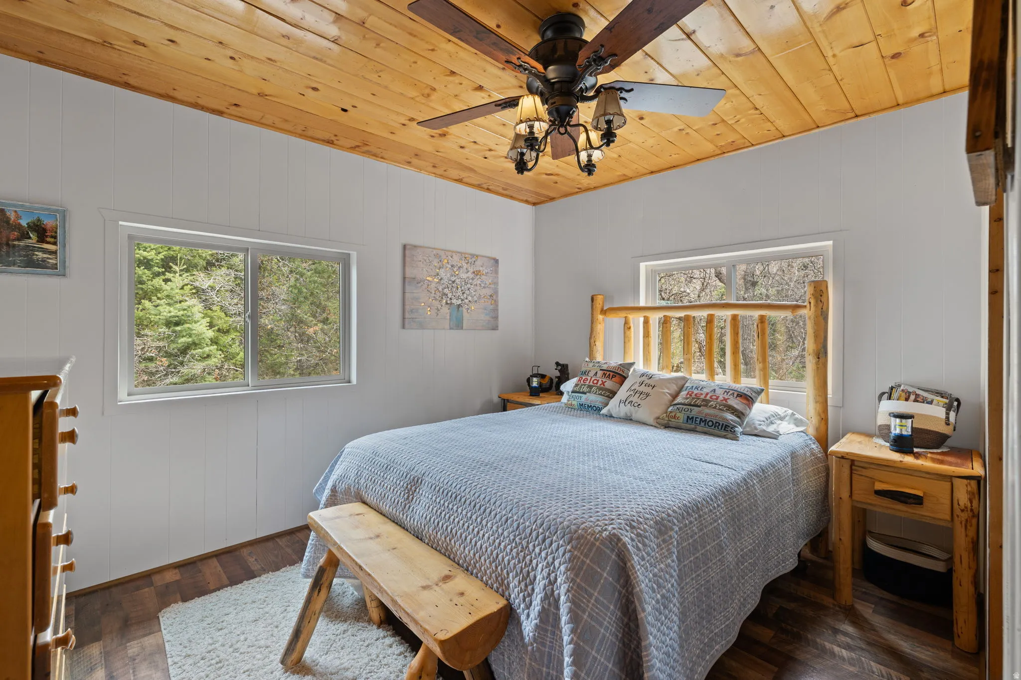 Cabin 2 - East; Bedroom featuring wood ceiling, a ceiling fan, multiple windows, and dark wood-style floors
