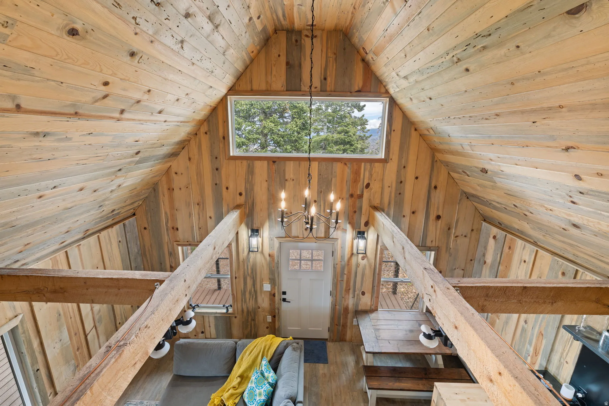 Cabin 1 - West; Upstairs loft featuring wooden ceiling, suspended lighting, and wood walls