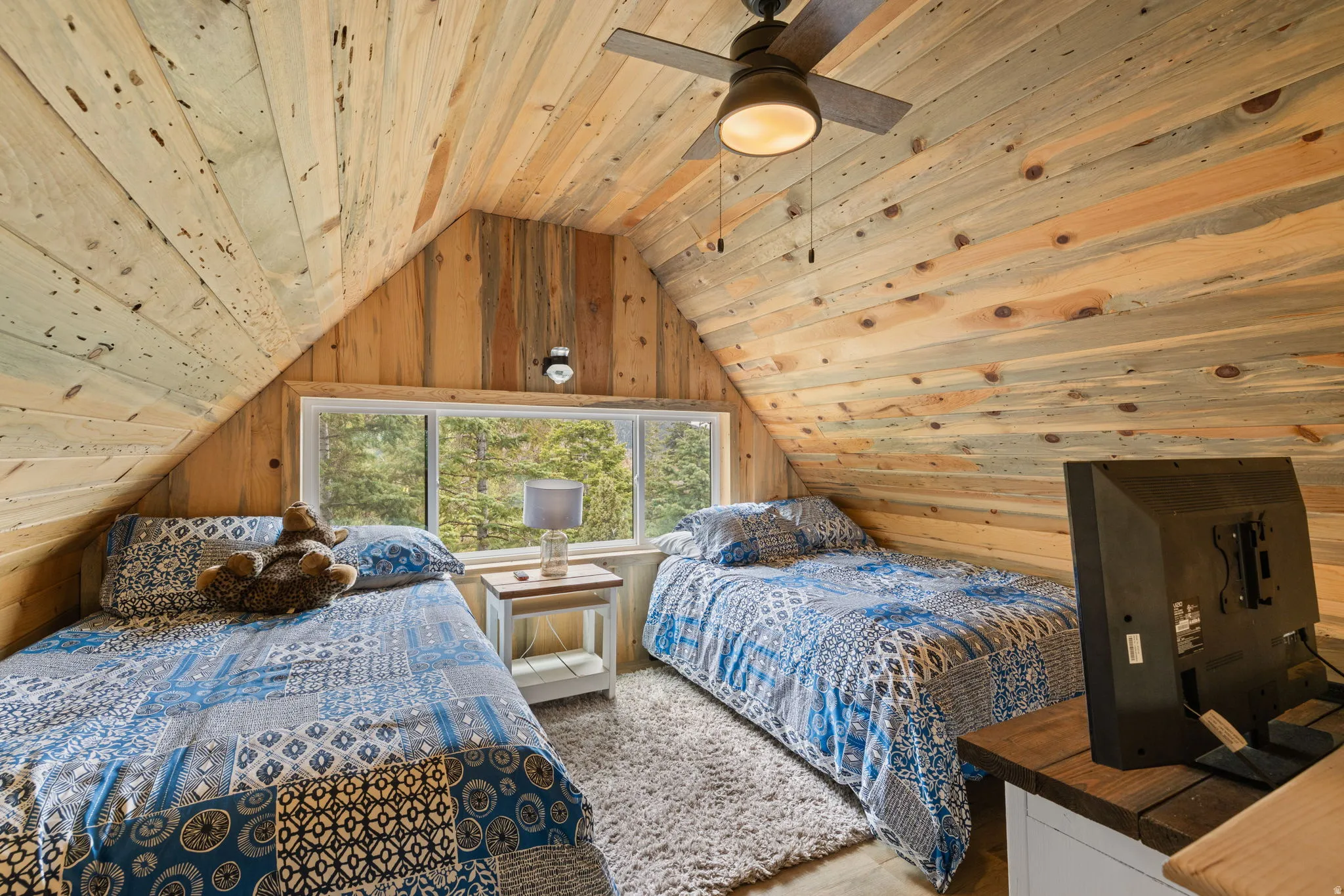 Cabin 1 - West; Upstairs loft/Bedroom with wood walls, wooden ceiling, and ceiling fan