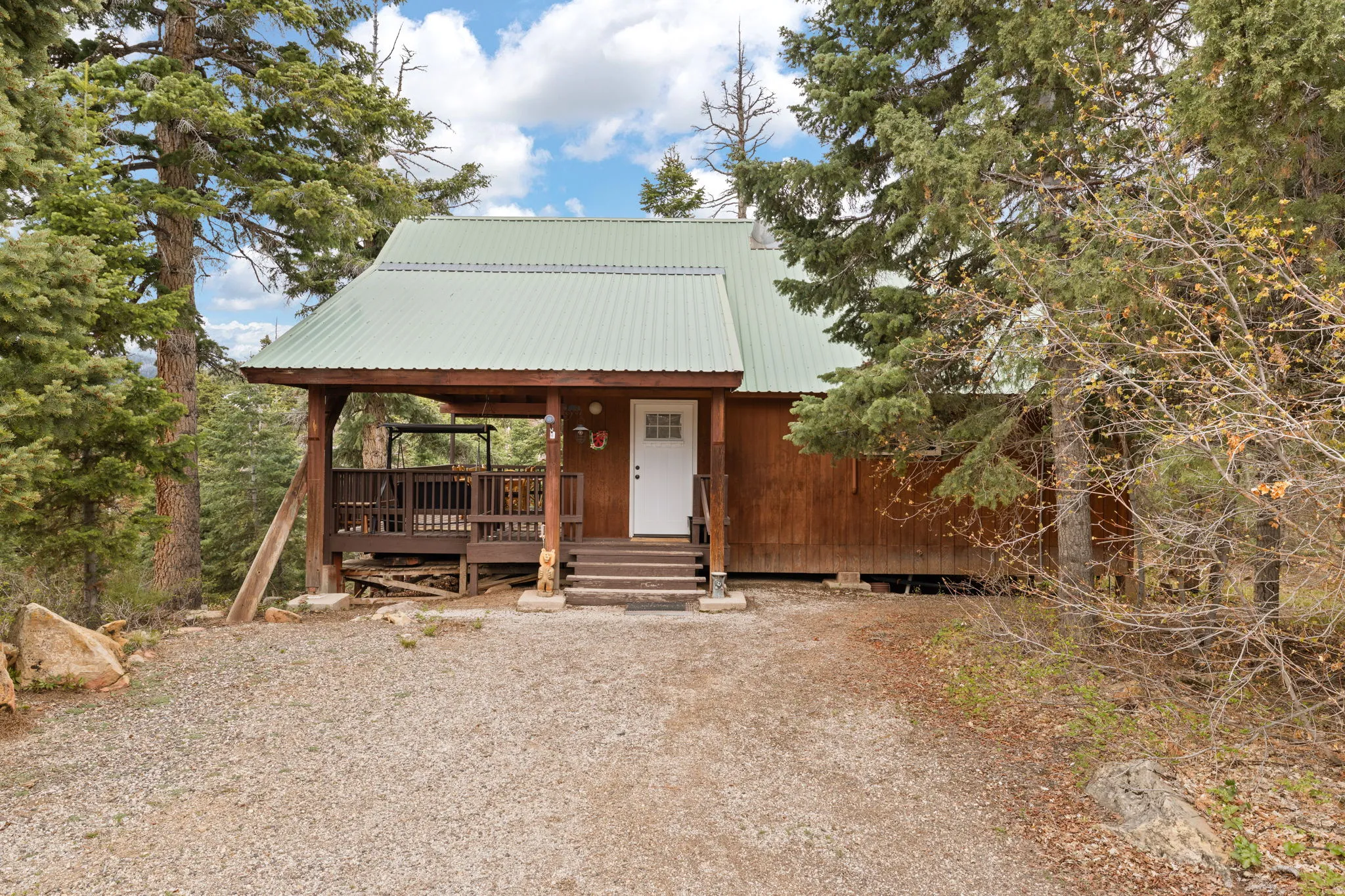Cabin 2 - East; Rustic home featuring covered porch and a metal roof
