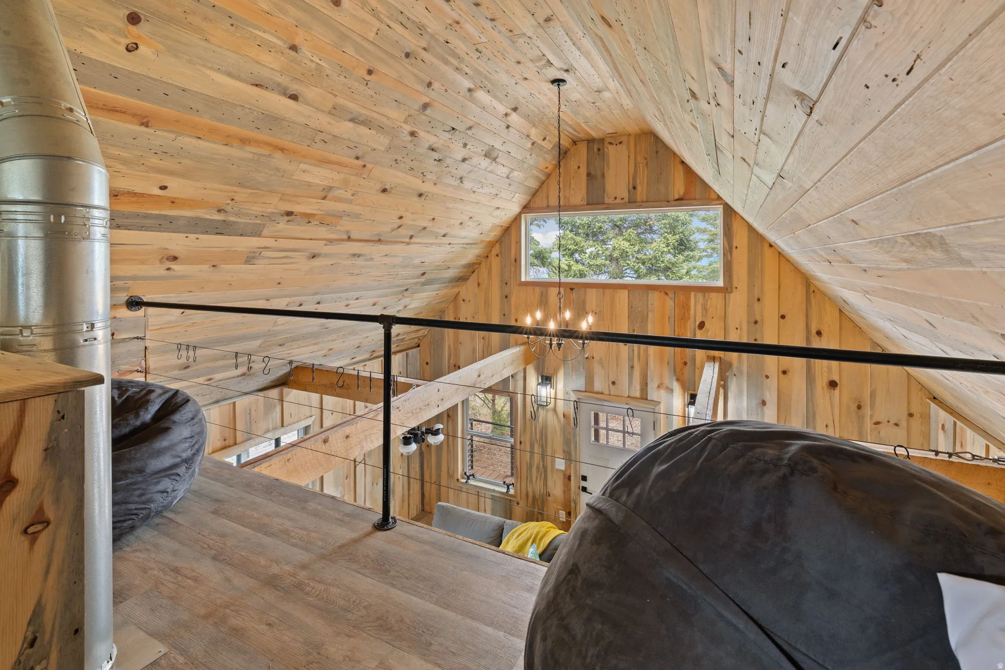 Cabin 1 - West; Upstairs loft/bedroom featuring wood walls and wooden ceiling