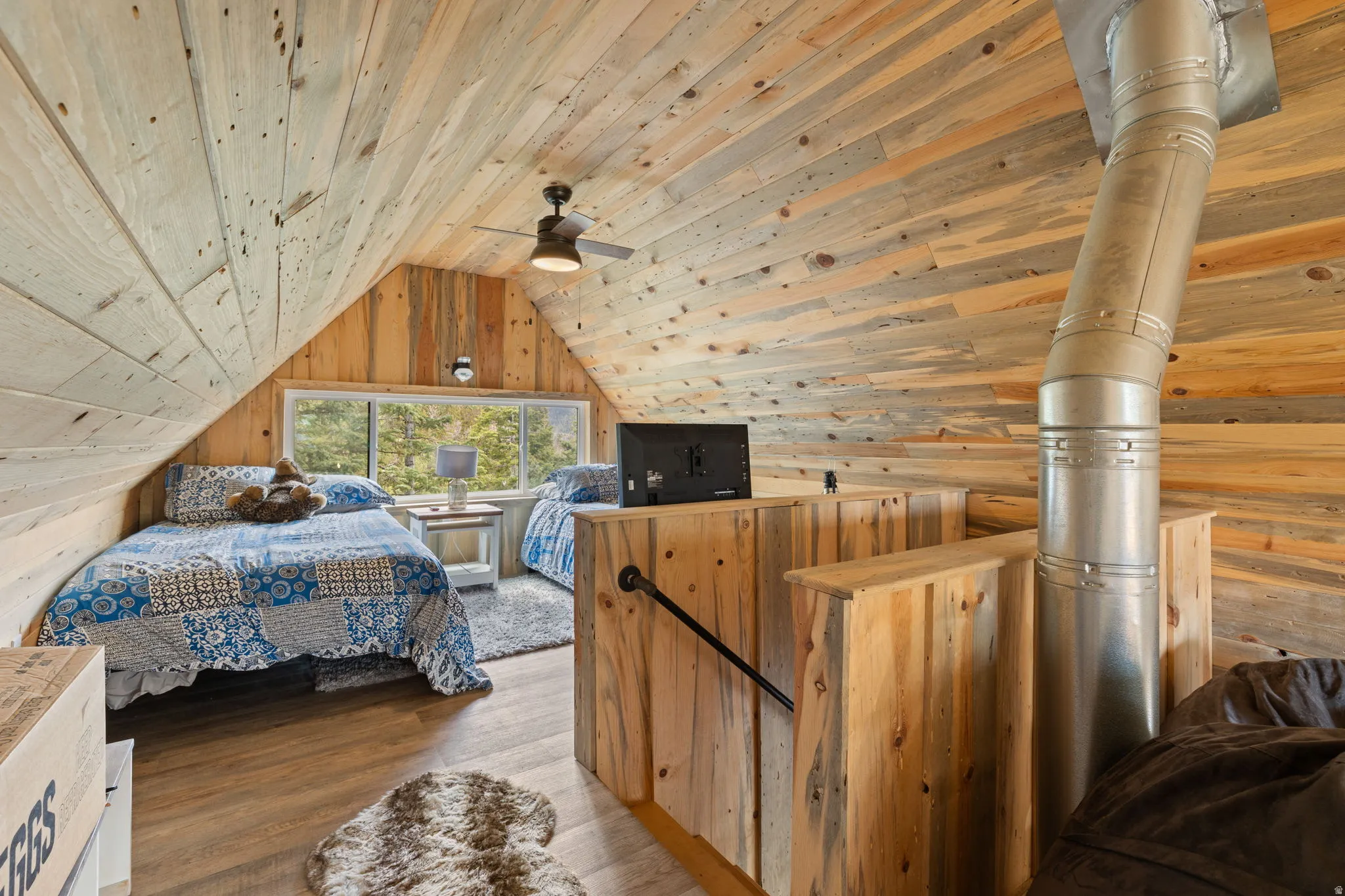 Cabin 1 - West; Upstairs loft/bedroom with wood walls, wood ceiling, wood finished floors, and ceiling fan