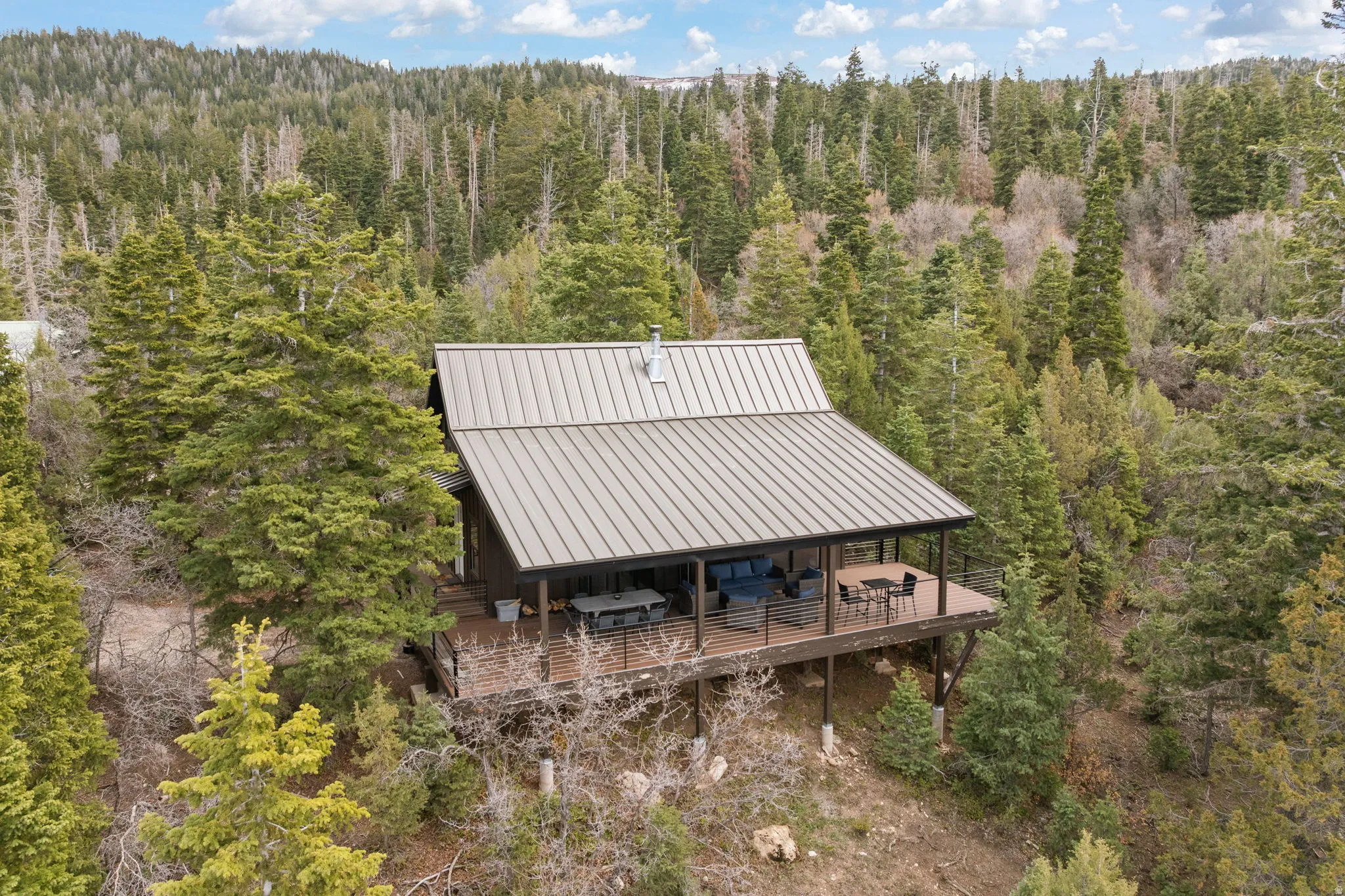 Cabin 1 - West; Aerial view of property and surrounding area featuring a heavily wooded area