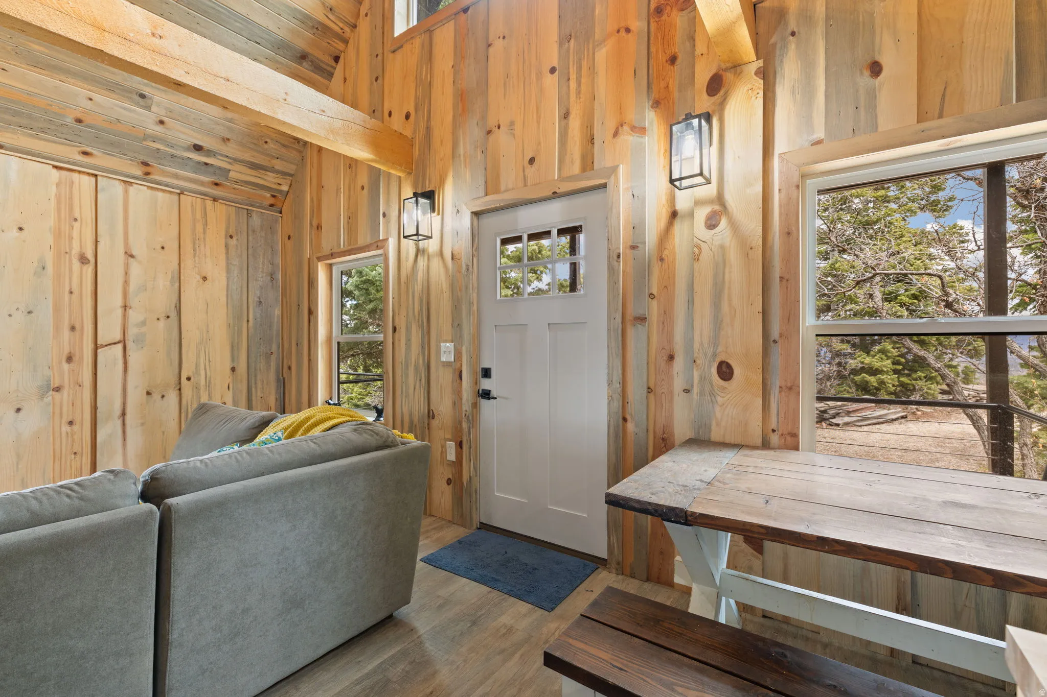 Cabin 1 - West; Foyer with wooden walls, lofted ceiling, and wood finished floors