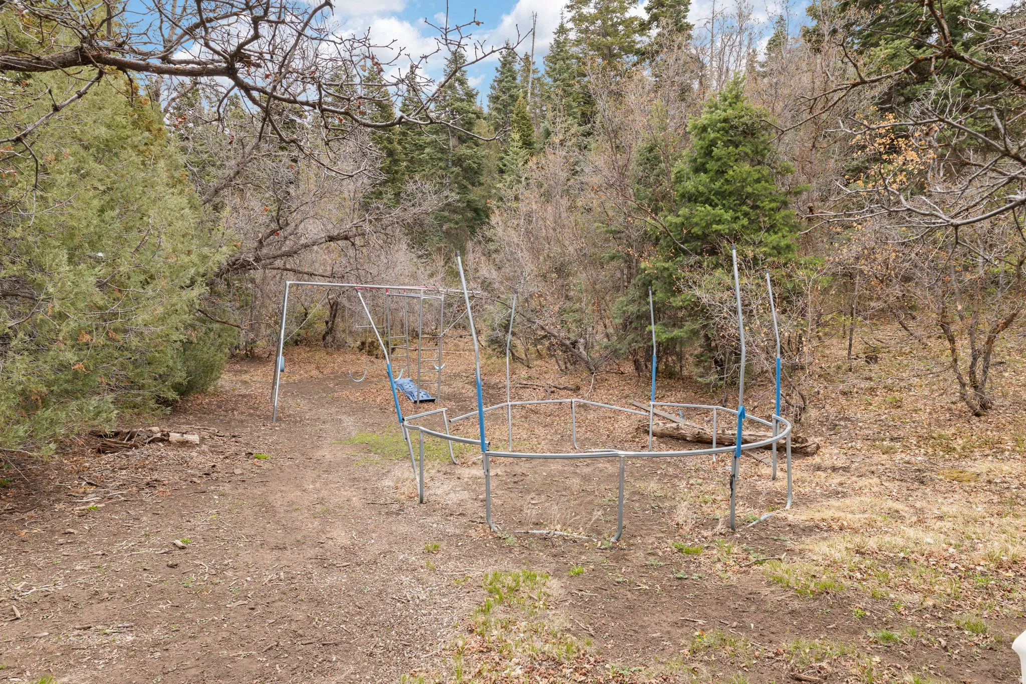 Cabin 2 - East; View of yard with a trampoline and a playground