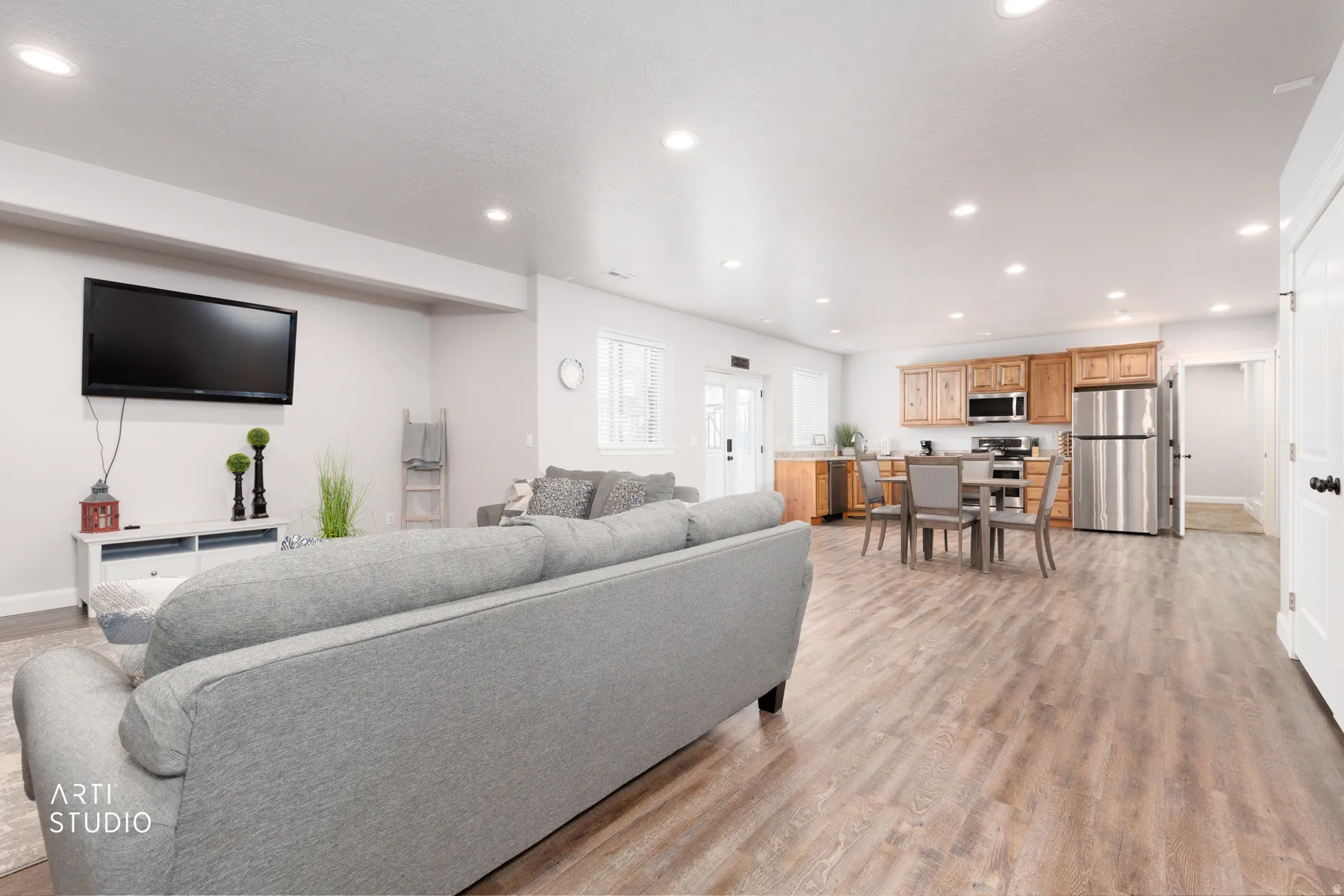 Living room with light wood-style flooring and recessed lighting