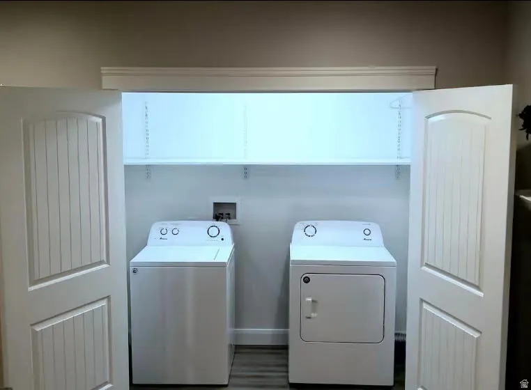 Laundry area featuring washing machine and dryer and wood finished floors
