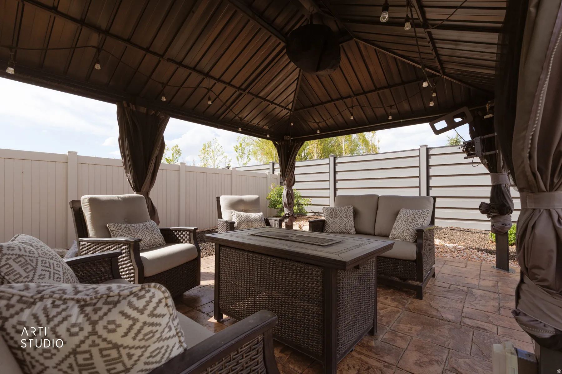 Fenced backyard featuring an outdoor hangout area, a patio area, and a gazebo