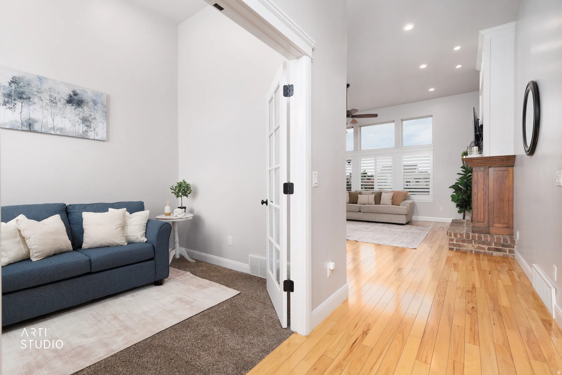 Living room with light wood-style floors, recessed lighting, ceiling fan, and light colored carpet