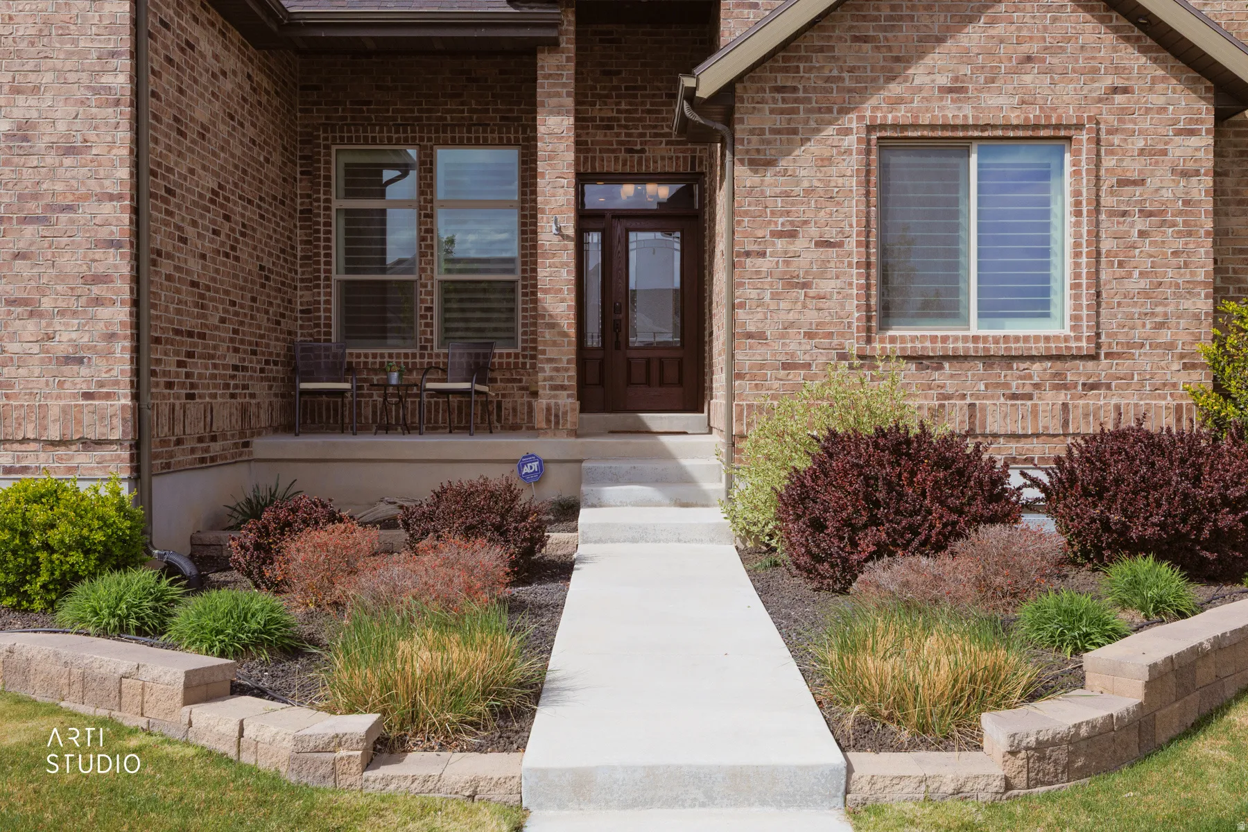 View of exterior entry featuring brick siding and covered porch