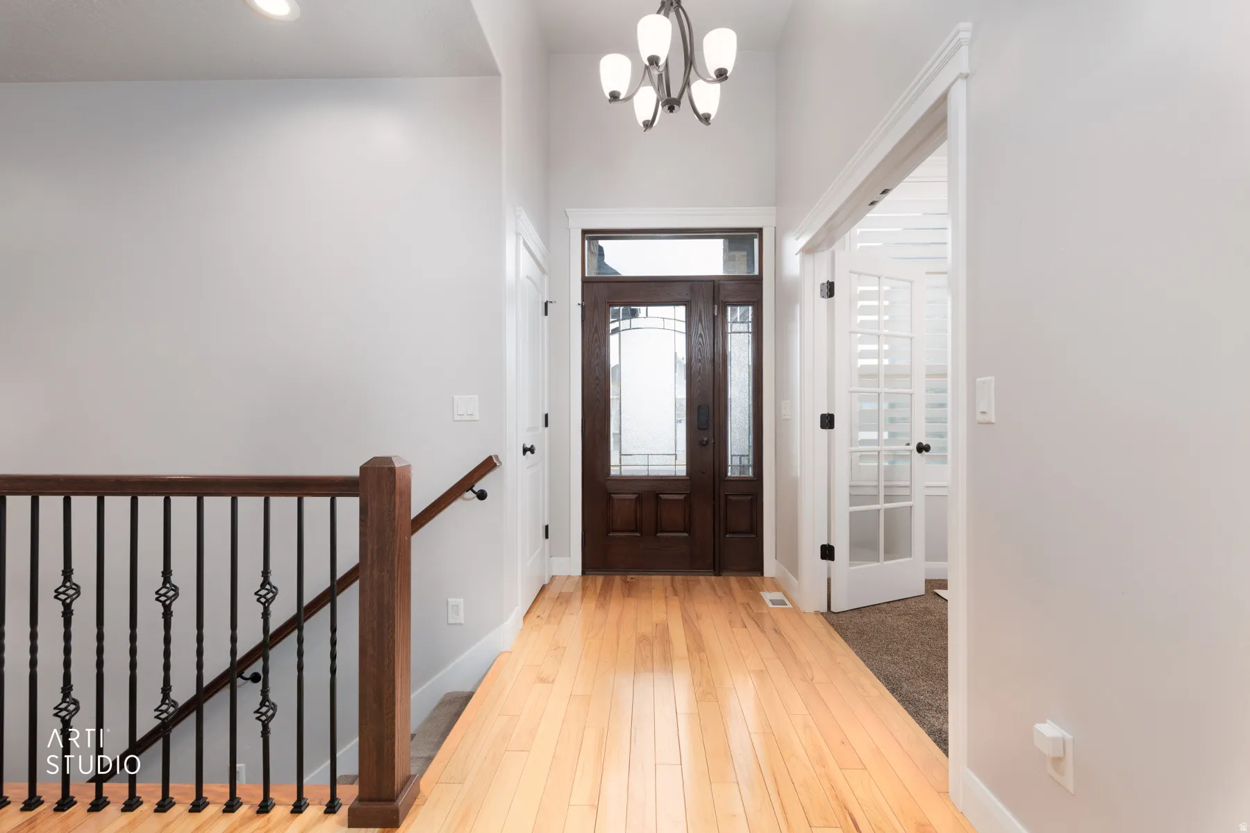 Foyer featuring light wood finished floors and suspended lighting