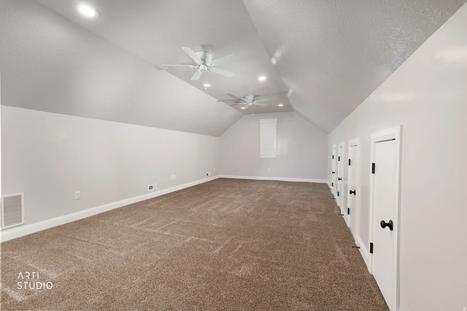 Additional living space with carpet flooring, ceiling fan, and a textured ceiling