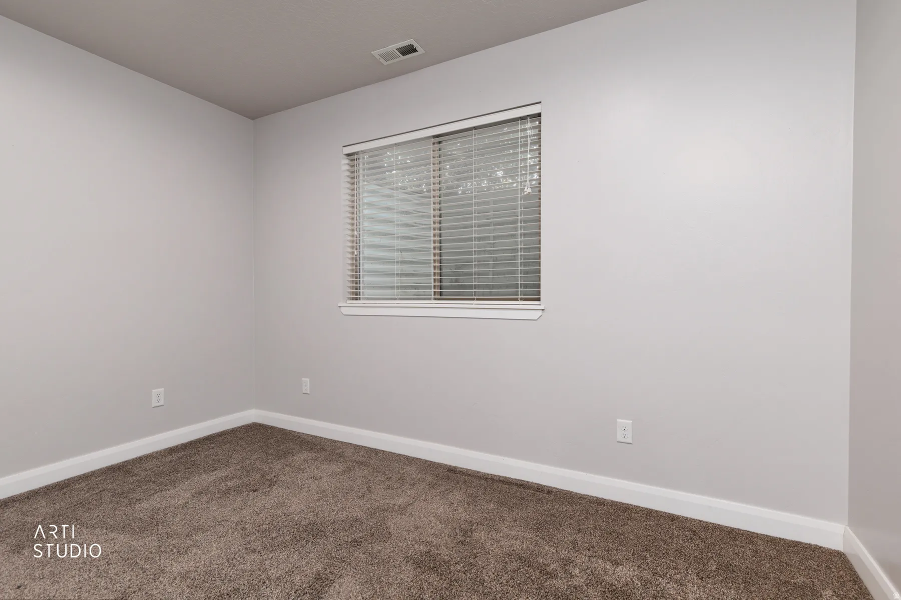 Unfurnished room with baseboards and dark carpet