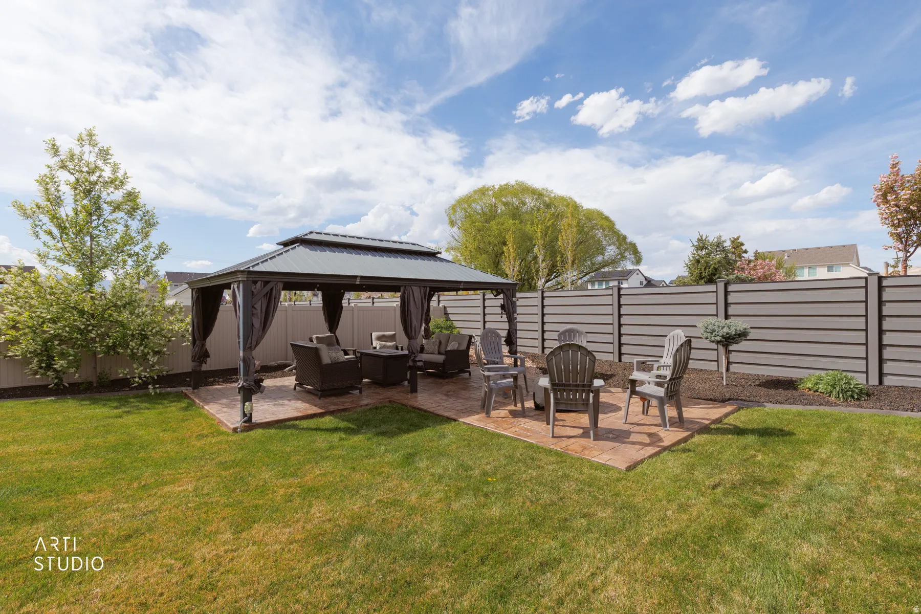 Fenced backyard with outdoor seating, a patio, and a gazebo