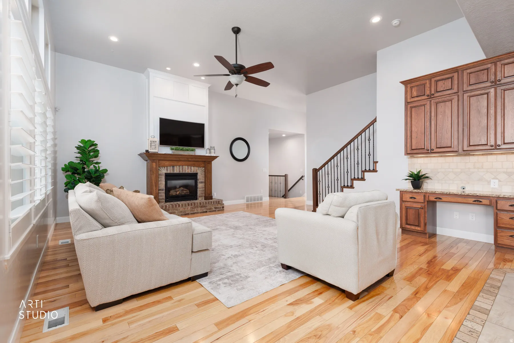 Living area featuring built in desk, light wood-type flooring, a ceiling fan, a brick fireplace, and recessed lighting