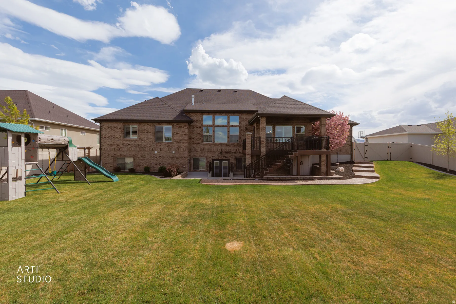 Rear view of house with brick siding, a patio area, a gate, and a fenced backyard