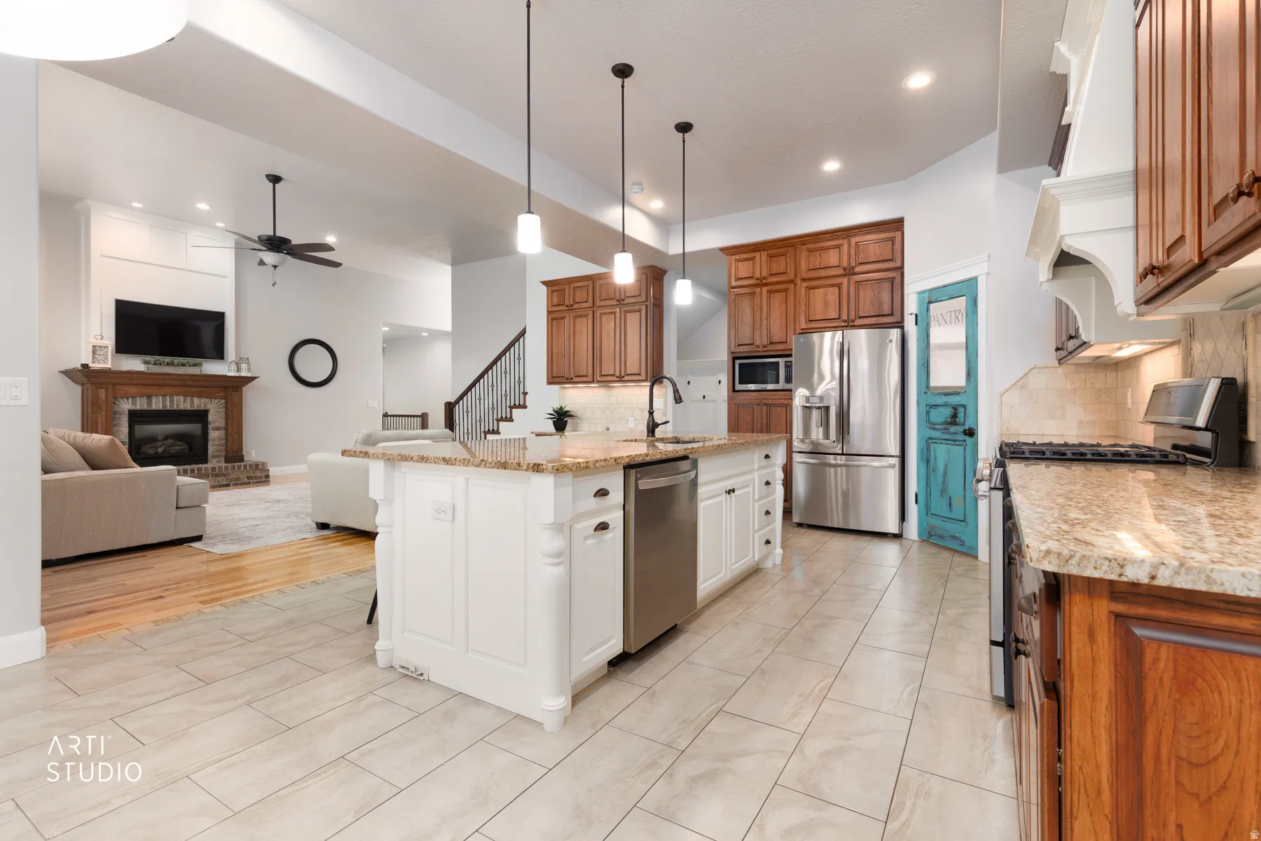 Kitchen with two tone color scheme, stainless steel appliances, light stone countertops, a kitchen breakfast bar, and open floor plan