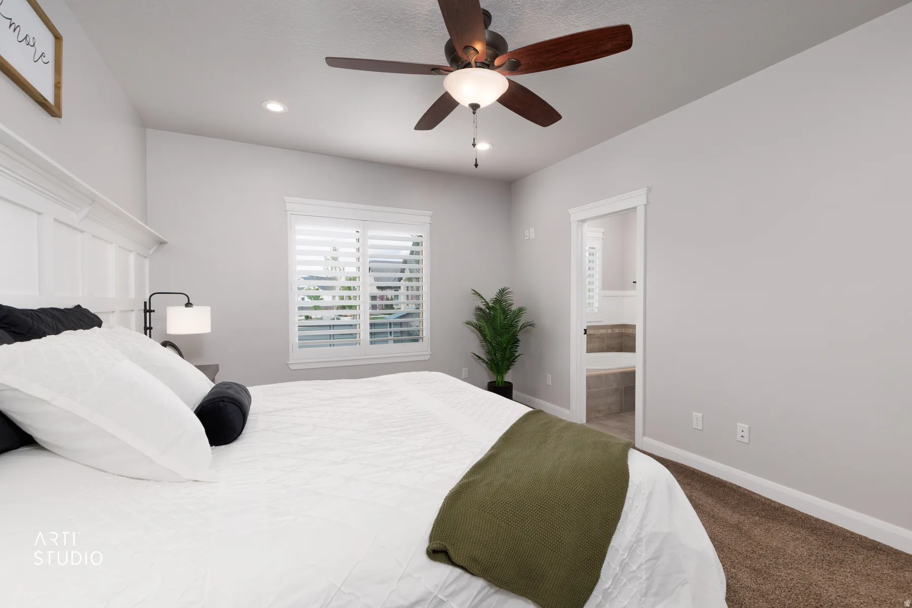Bedroom with dark carpet, ceiling fan, ensuite bathroom, and recessed lighting
