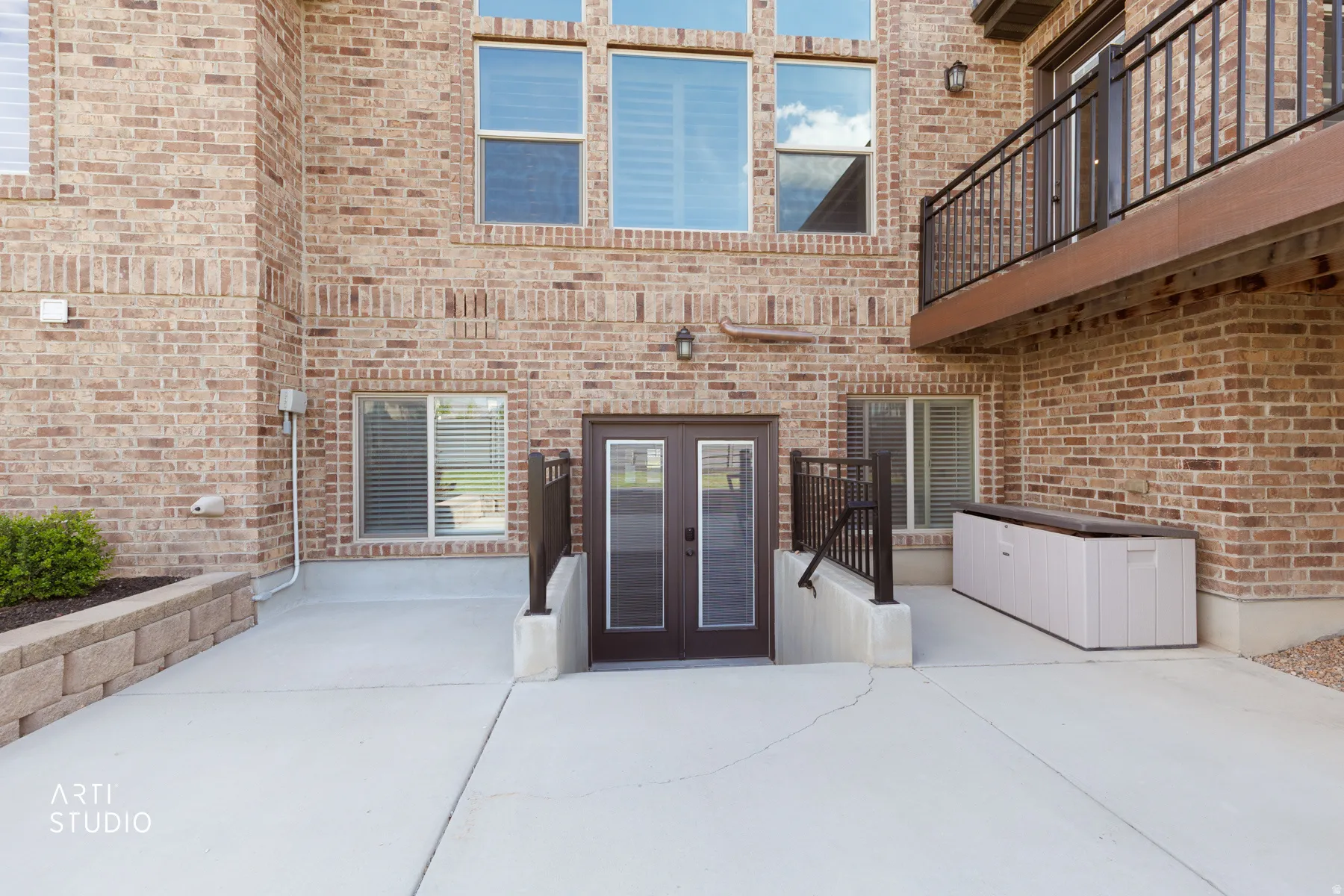 View of exterior entry with brick siding, a patio area, and french doors