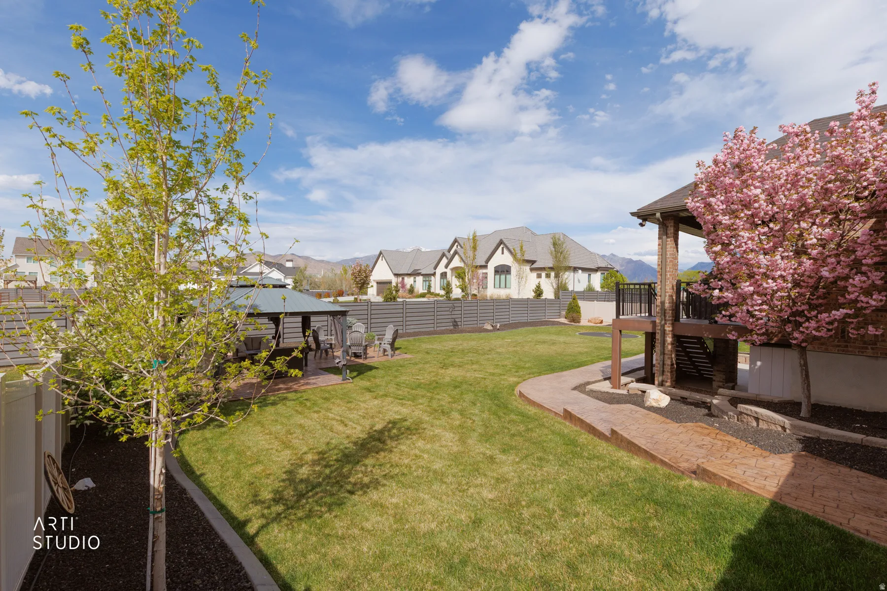 Fenced backyard with a patio area, a residential view, and a gazebo