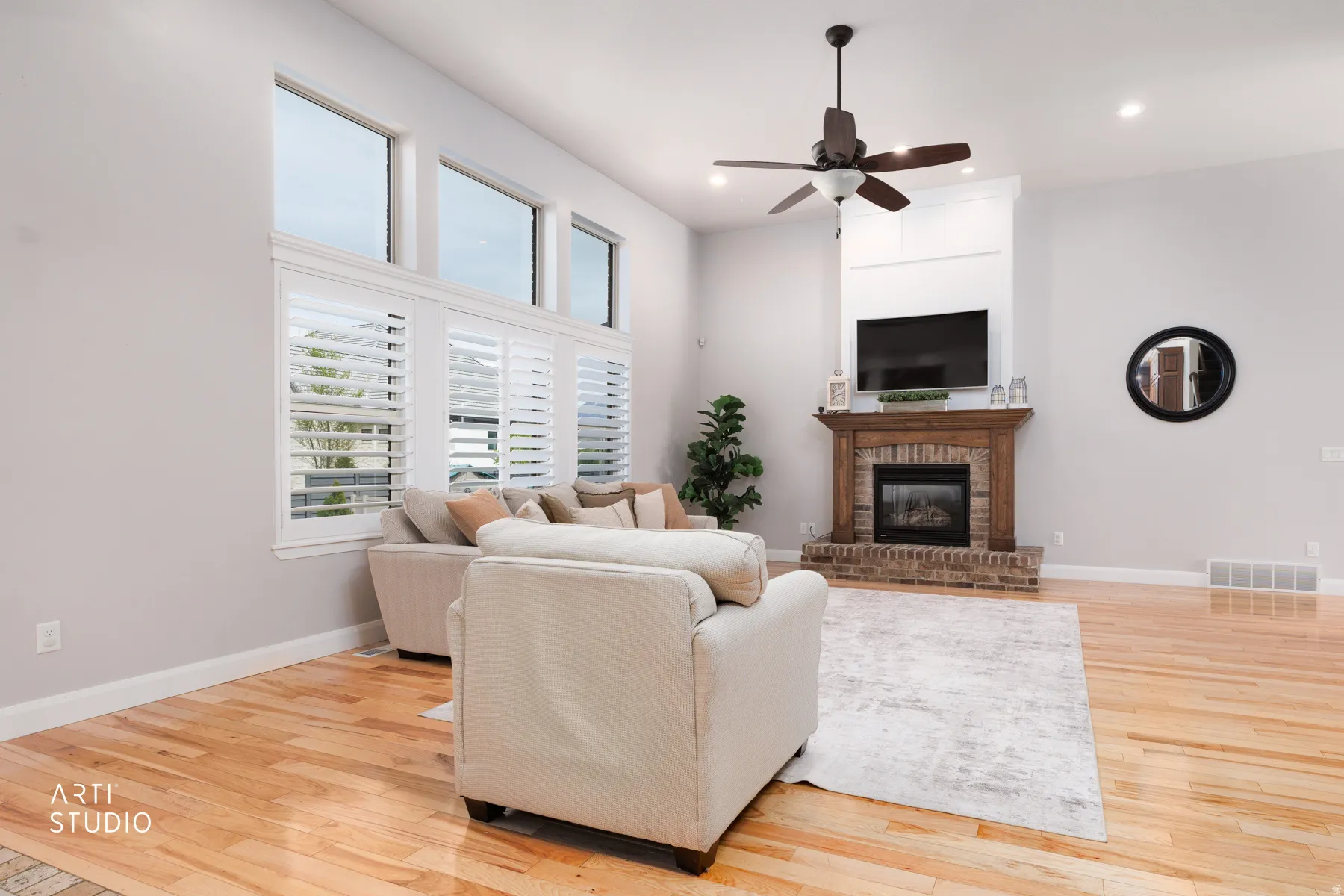 Living area featuring light wood-style flooring, ceiling fan, a brick fireplace, and recessed lighting