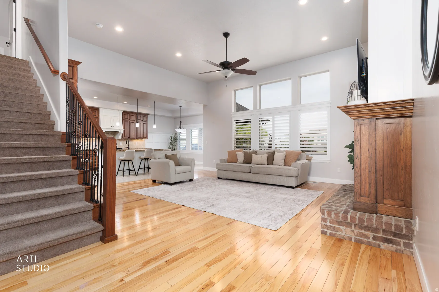 Living room featuring light wood-style floors, recessed lighting, ceiling fan, and a high ceiling
