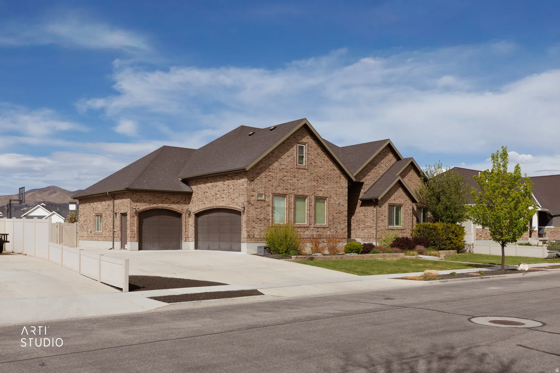 French country home with brick siding, concrete driveway, a garage, and roof with shingles